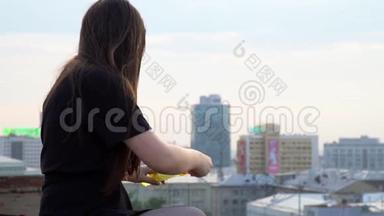 这个女孩在高楼的屋顶上花钱。那个长头发的女孩在楼顶上冒泡泡。可爱的